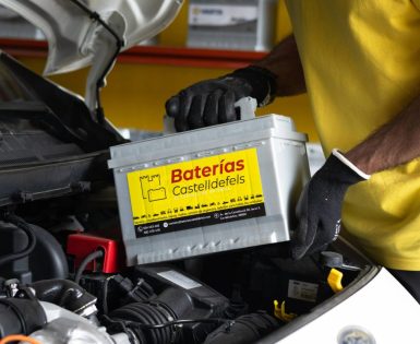 Un electromecanico está cambiando la batería para un coche